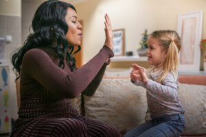 image of African American woman playing with girl.